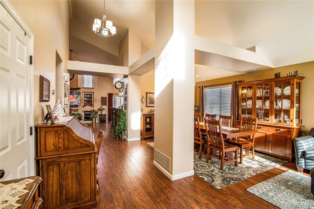 a view of a dining room and livingroom with furniture wooden floor a chandelier