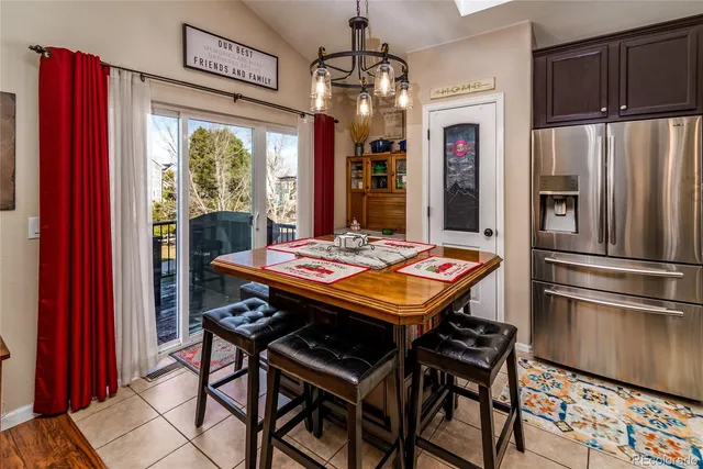 a kitchen that has a table chairs and refrigerator