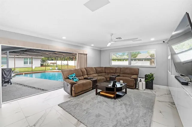 a bedroom with a bed a couch and large windows