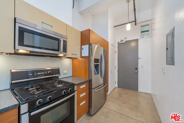 a kitchen with stainless steel appliances granite countertop a sink a stove and a refrigerator