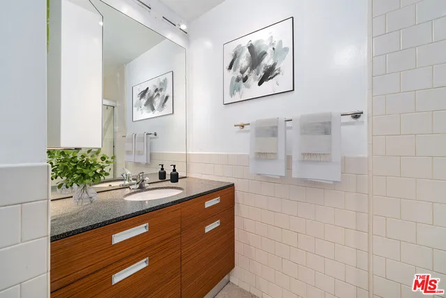 a bathroom with a sink a mirror and a shower