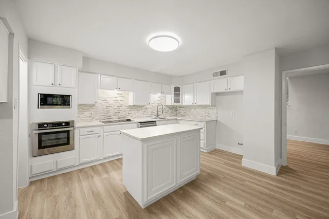 a kitchen with white cabinets and white appliances