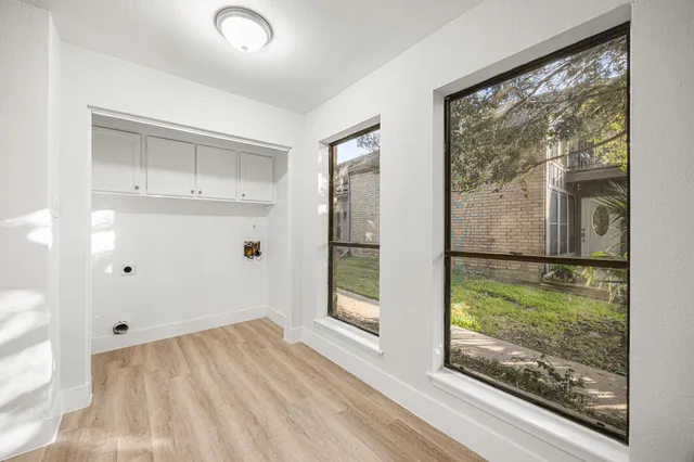 a view of a room with wooden floor and windows