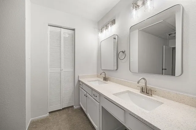 a bathroom with double vanity sink and two mirror