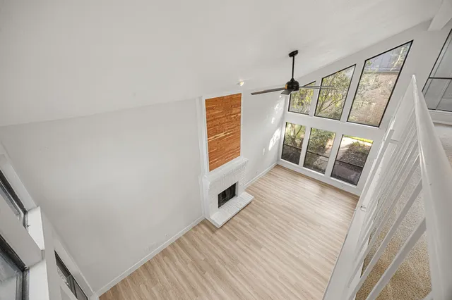 a view of hallway with wooden floor and cabinet