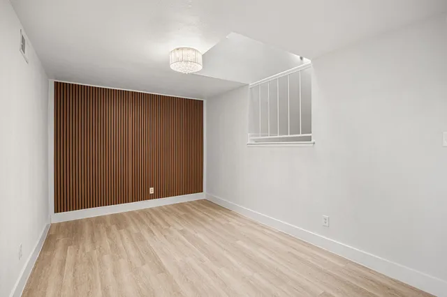 a view of an empty room with closet and a window