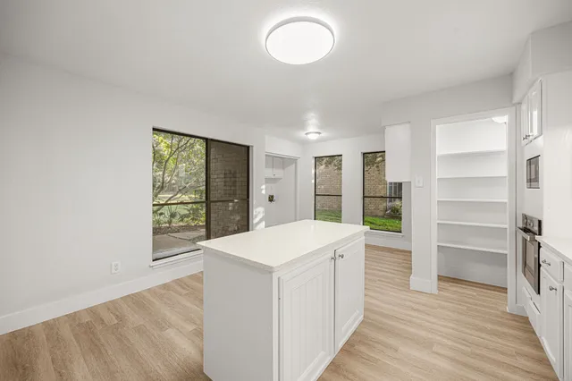 a view of a kitchen with fridge and wooden floor