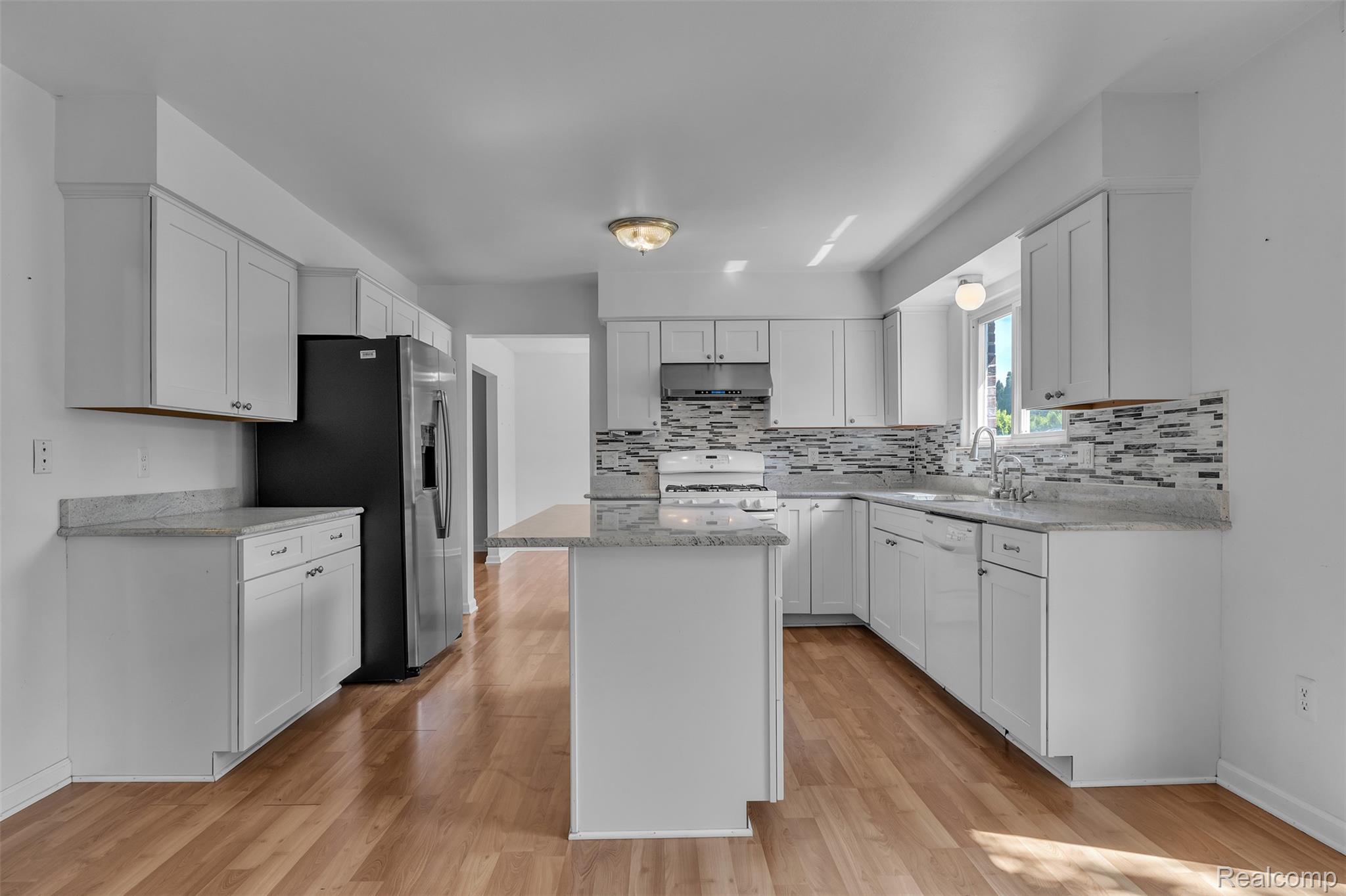 7000 Woonsocket Street Canton, MI 48187 - Photo 18 of 65 Kitchen featuring white cabinetry, granite countertops, tile backsplash, stainless steel appliances, and wood-finish flooring