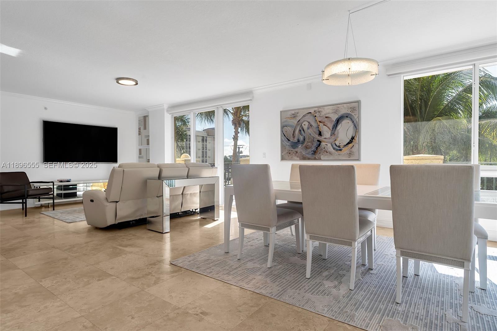 9 Northeast 20th Avenue, Unit 302 Deerfield Beach, FL 33441 - Photo 16 of 55 a living room with furniture a flat screen tv and floor to ceiling window