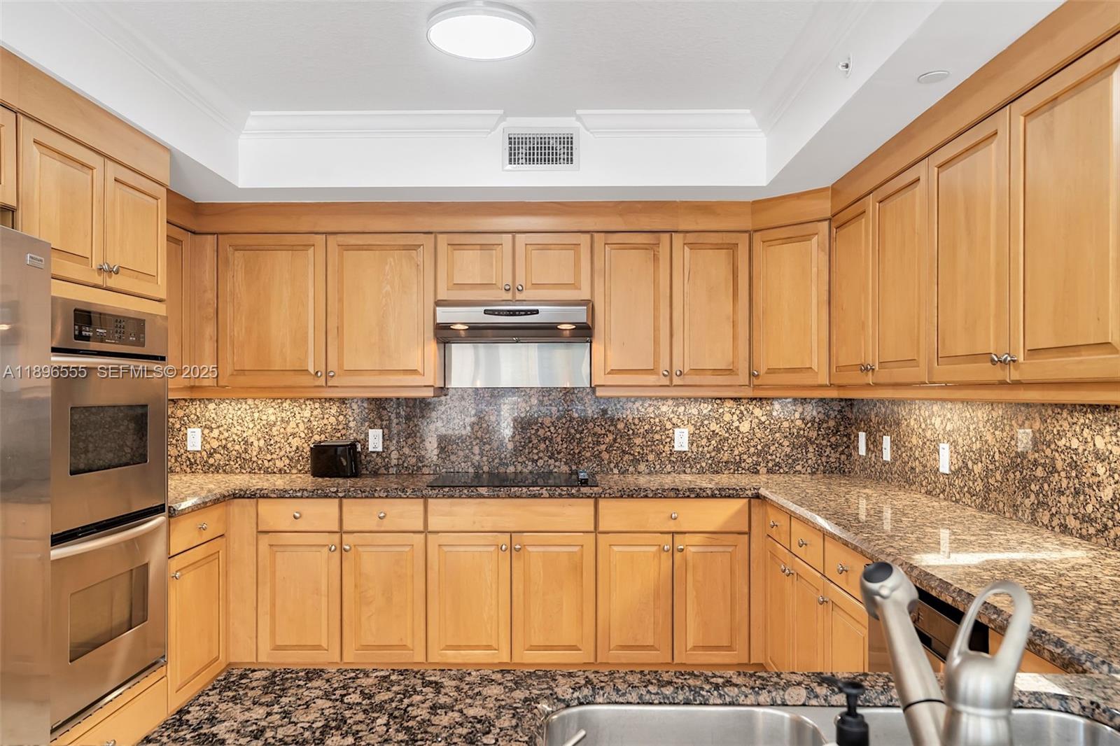 9 Northeast 20th Avenue, Unit 302 Deerfield Beach, FL 33441 - Photo 29 of 55 a kitchen with stainless steel appliances granite countertop a sink stove and cabinets