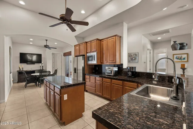 a kitchen with granite countertop a sink a counter top space appliances and cabinets