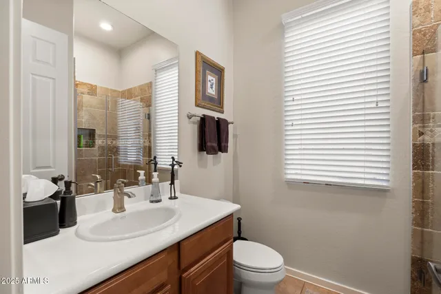 a bathroom with a sink toilet vanity and window
