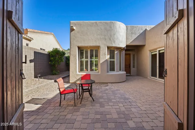 a view of a patio with table and chairs and wooden fence