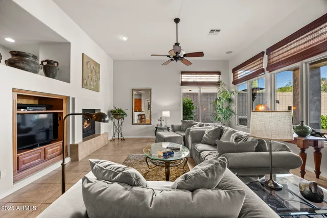 a living room with furniture a ceiling fan and a fireplace
