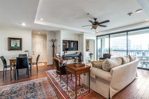 a living room with furniture a flat screen tv and a large window