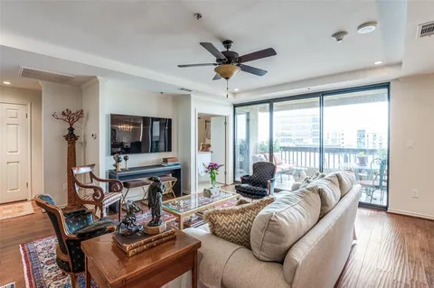 a living room with furniture a flat screen tv and a large window