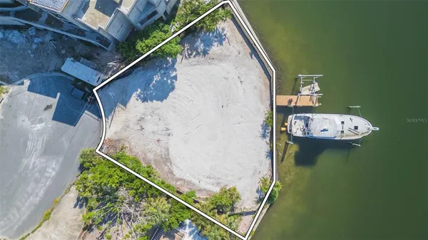 an aerial view of a house with a yard and lake view