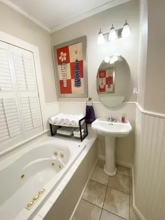 a bathroom with a sink tub and a mirror