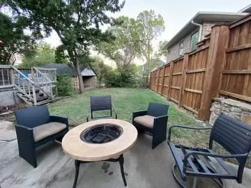 a view of a chairs and table in backyard
