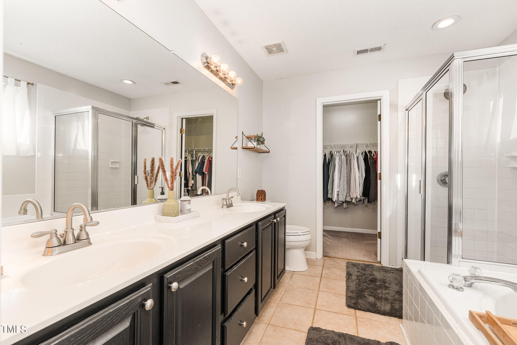 8516 Metronome Lane Raleigh, NC 27613 - Photo 18 of 25 a spacious bathroom with a double vanity sink a mirror and a shower