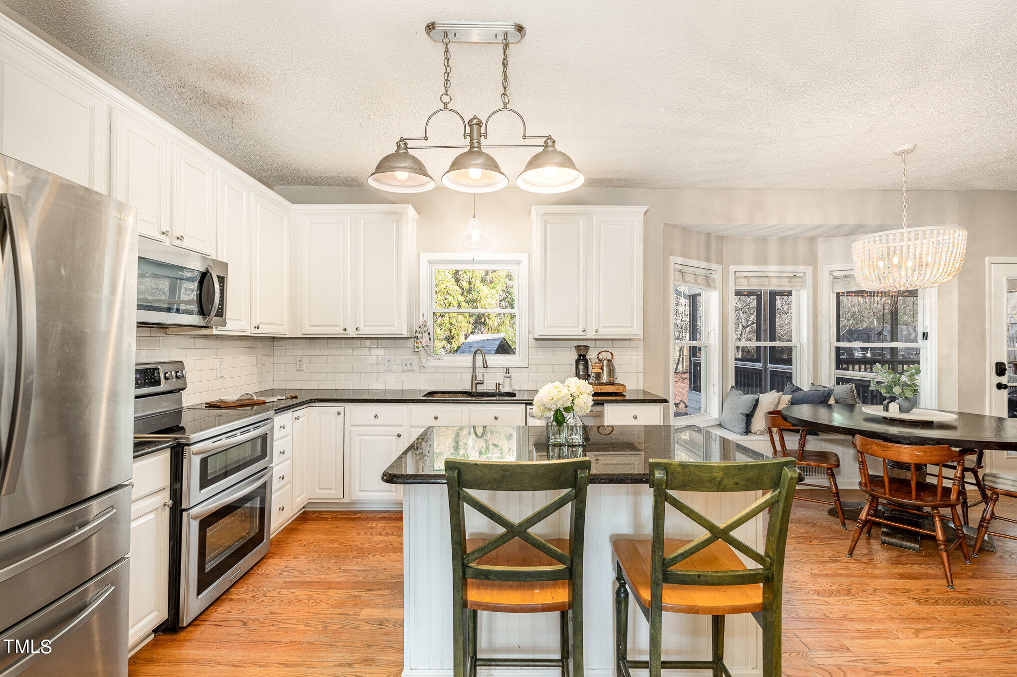 8516 Metronome Lane Raleigh, NC 27613 - Photo 2 of 25 a kitchen with stainless steel appliances granite countertop wooden floor a stove a sink dishwasher and a refrigerator with wooden floor