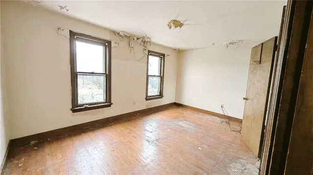 an empty room with windows and closet