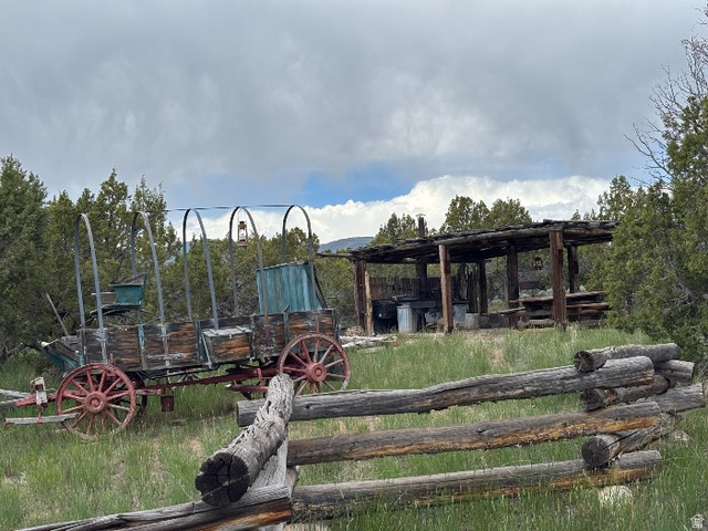 14908 North Deep Crk Road Lapoint, UT 84039 - Photo 6 of 9 Rustic wooden split-rail fence enclosing a grassy area with mature trees and a substantial covered outdoor structure
