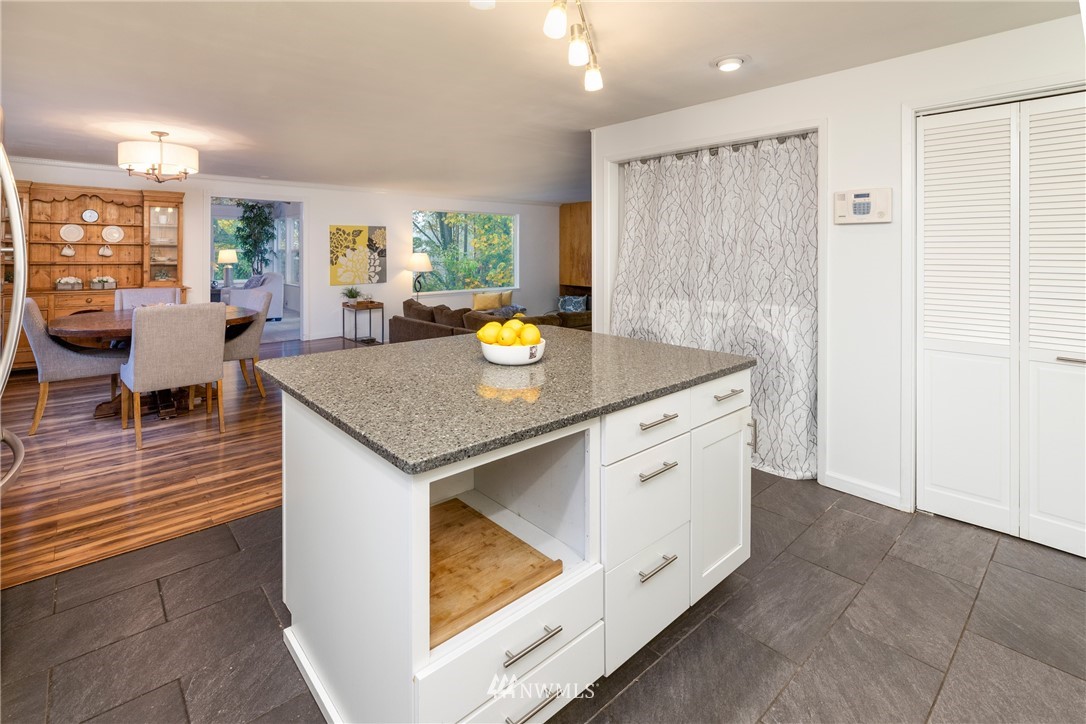 16945 Southeast 149th Street Renton, WA 98059 - Photo 12 of 40 a view of kitchen island with stainless steel appliances granite countertop lots of counter space and wooden floors