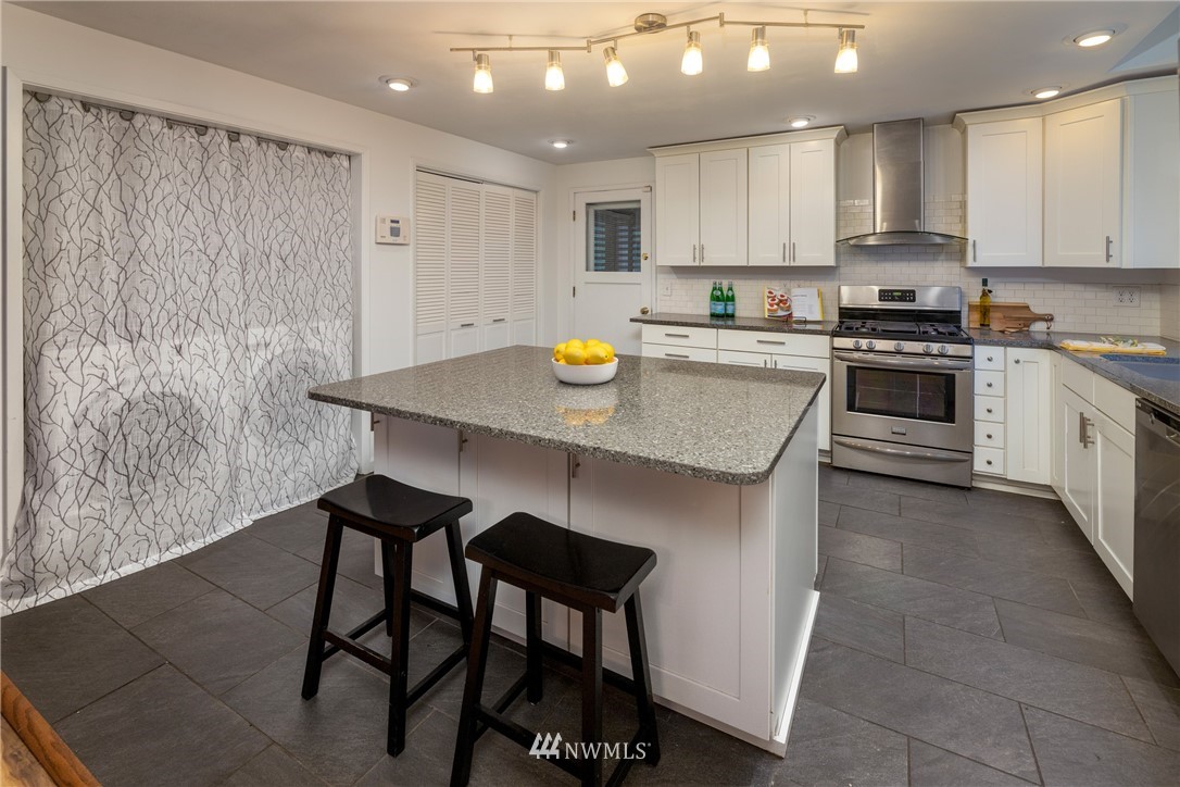 16945 Southeast 149th Street Renton, WA 98059 - Photo 13 of 40 a kitchen with stainless steel appliances granite countertop a stove a sink and a refrigerator