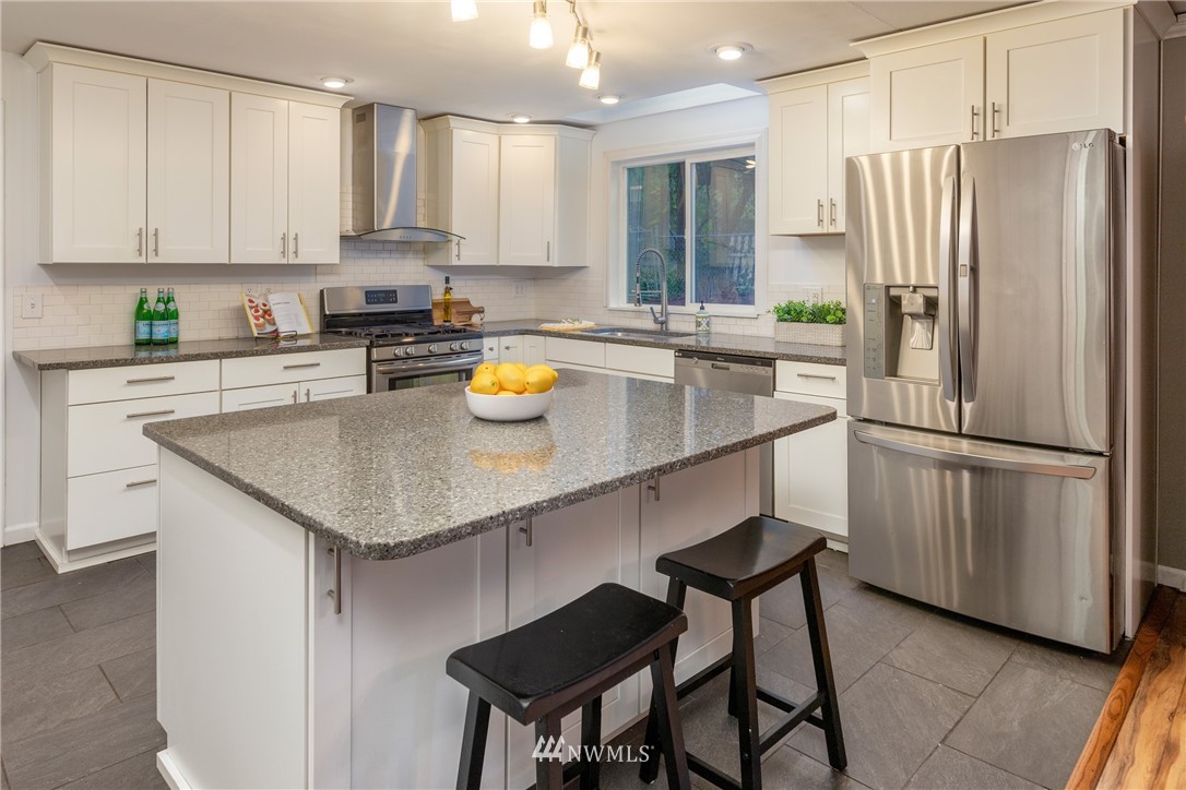 16945 Southeast 149th Street Renton, WA 98059 - Photo 10 of 40 a kitchen with stainless steel appliances a refrigerator a sink a stove a table and chairs