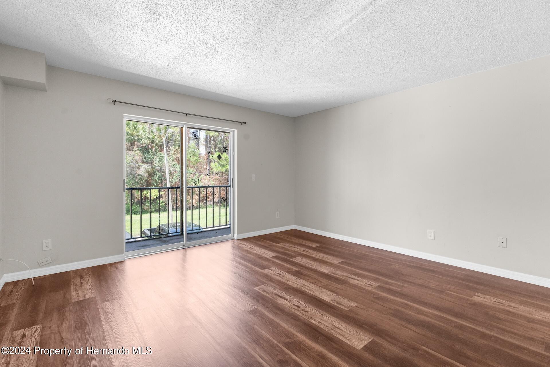 5541 Bay Boulevard Port Richey, FL 34668 - Photo 11 of 22 a view of an empty room with wooden floor and a window