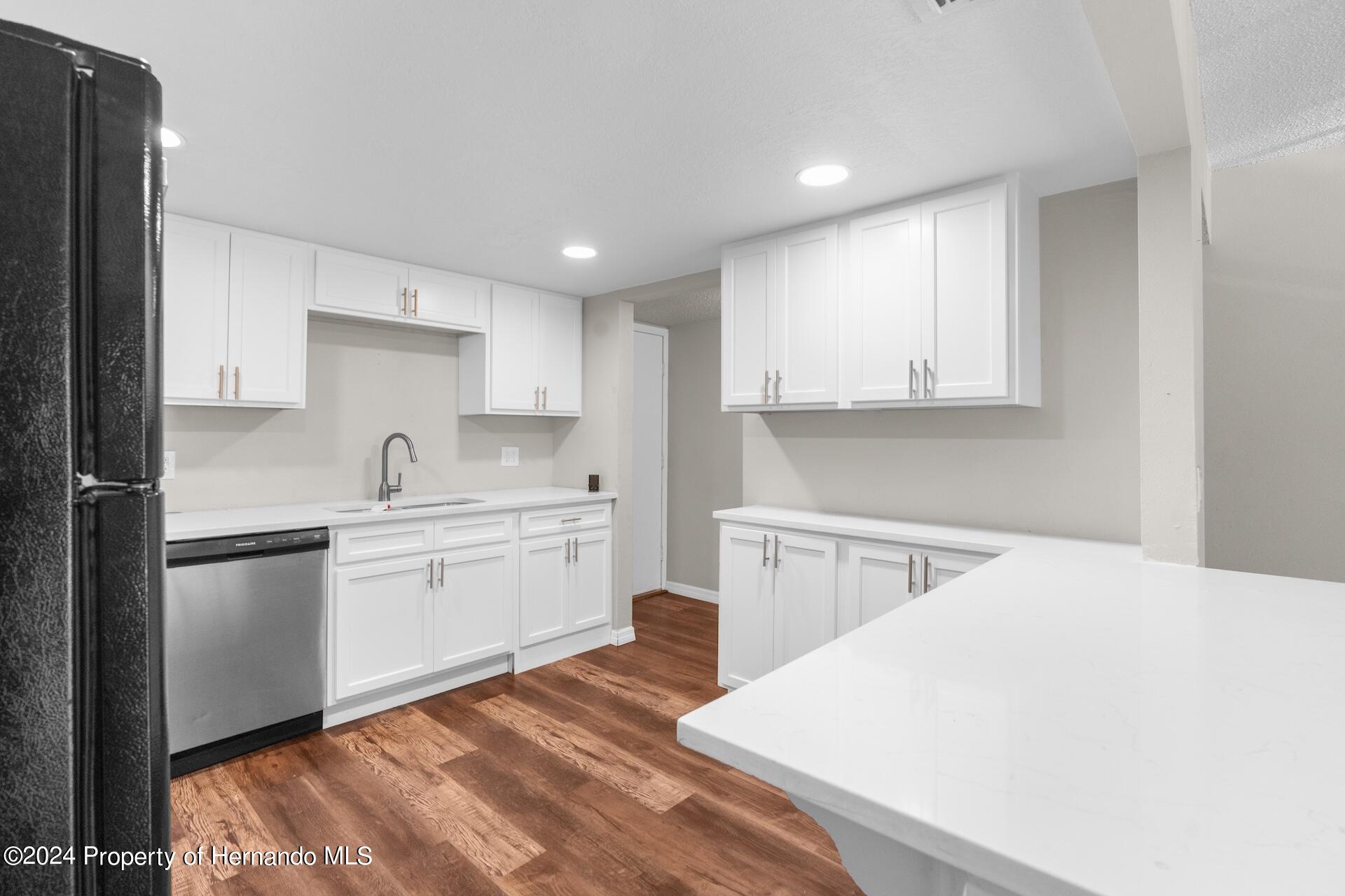 5541 Bay Boulevard Port Richey, FL 34668 - Photo 6 of 22 a kitchen with a sink stove and white cabinets
