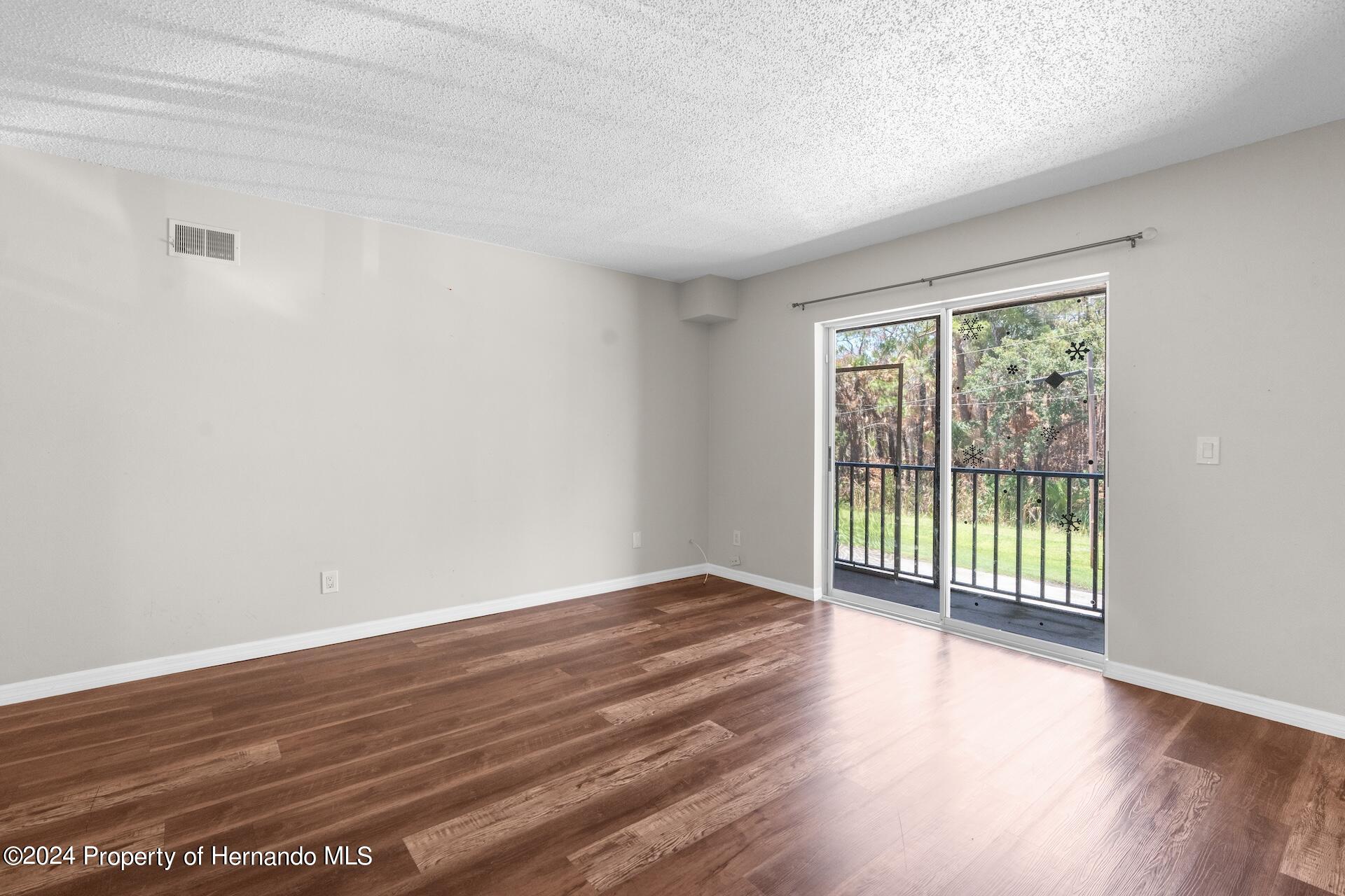 5541 Bay Boulevard Port Richey, FL 34668 - Photo 10 of 22 a view of an empty room with wooden floor and a window