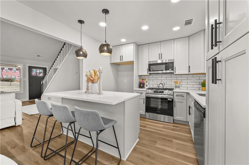 3413 Underwood Road Southeast Conyers, GA 30013 - Photo 13 of 42 a kitchen with stainless steel appliances kitchen island a refrigerator and a stove top oven