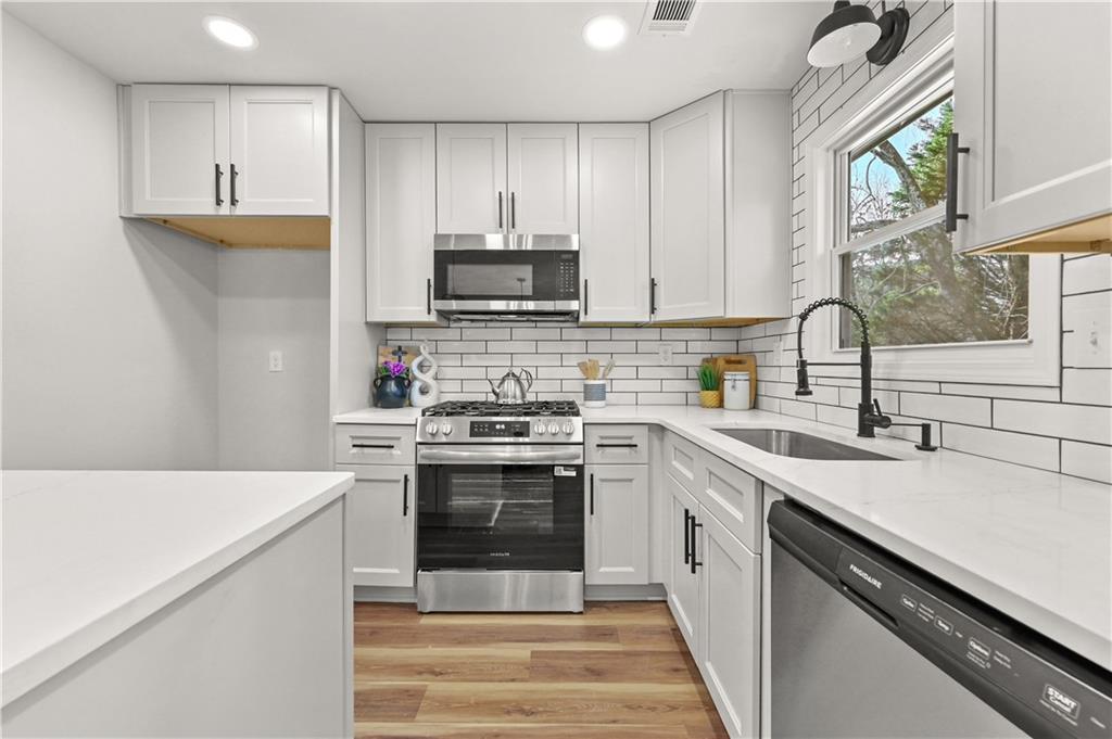 3413 Underwood Road Southeast Conyers, GA 30013 - Photo 14 of 42 a kitchen with stainless steel appliances a sink stove and white cabinets