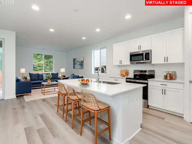 a kitchen with a sink a counter top space a large window and stainless steel appliances