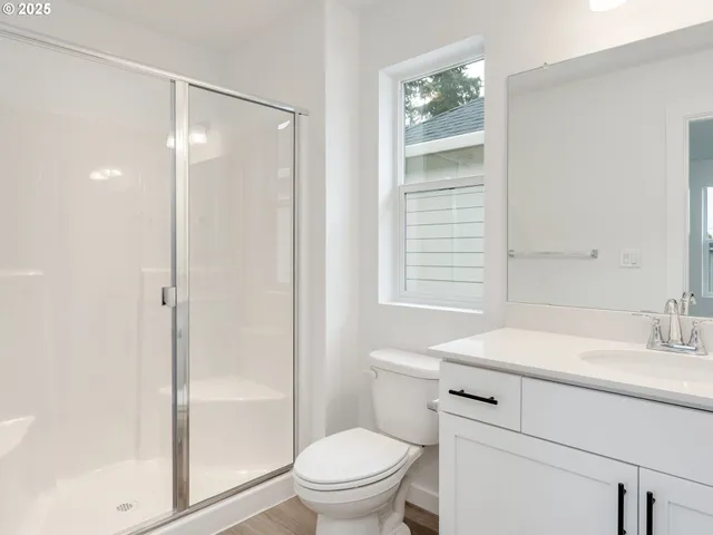 a bathroom with a sink toilet vanity and shower