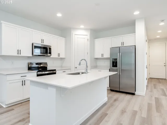 a kitchen with stainless steel appliances a refrigerator stove and microwave
