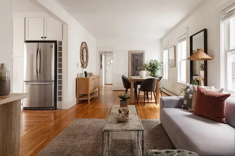 a living room with furniture a bed and a refrigerator