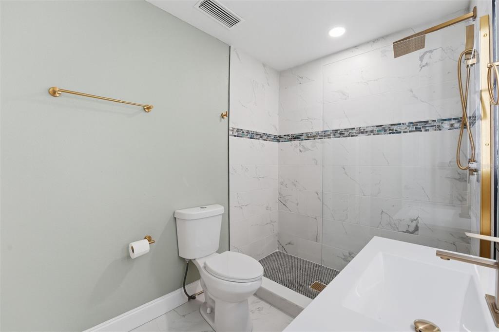 808 Guild Drive Venice, FL 34285 - Photo 18 of 27 a white toilet sitting next to a bathroom sink and vanity