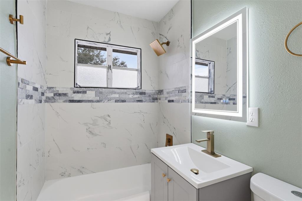 808 Guild Drive Venice, FL 34285 - Photo 9 of 27 a bathroom with a sink and mirror with toilet