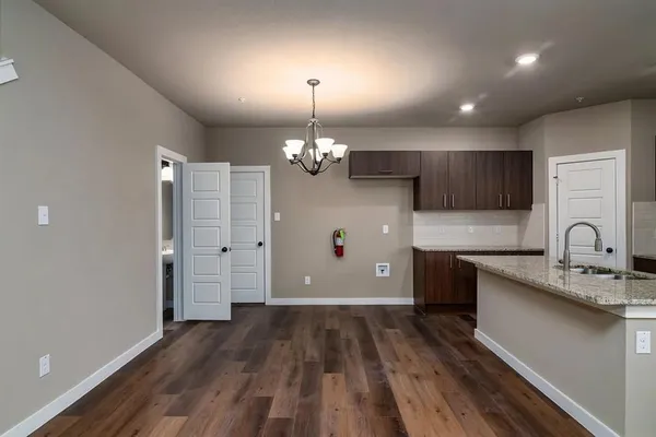 a view of an empty room with wooden floor and stairs
