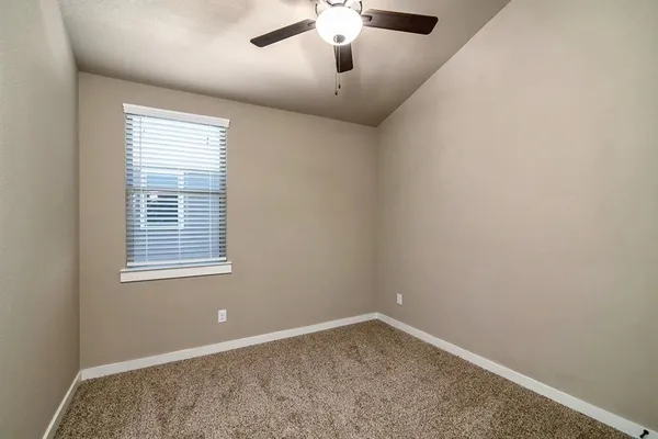 a view of an empty room with closet and a window