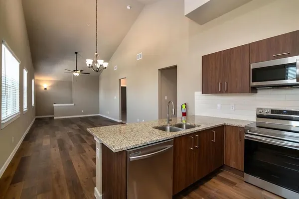 a kitchen with stainless steel appliances granite countertop a sink refrigerator and microwave