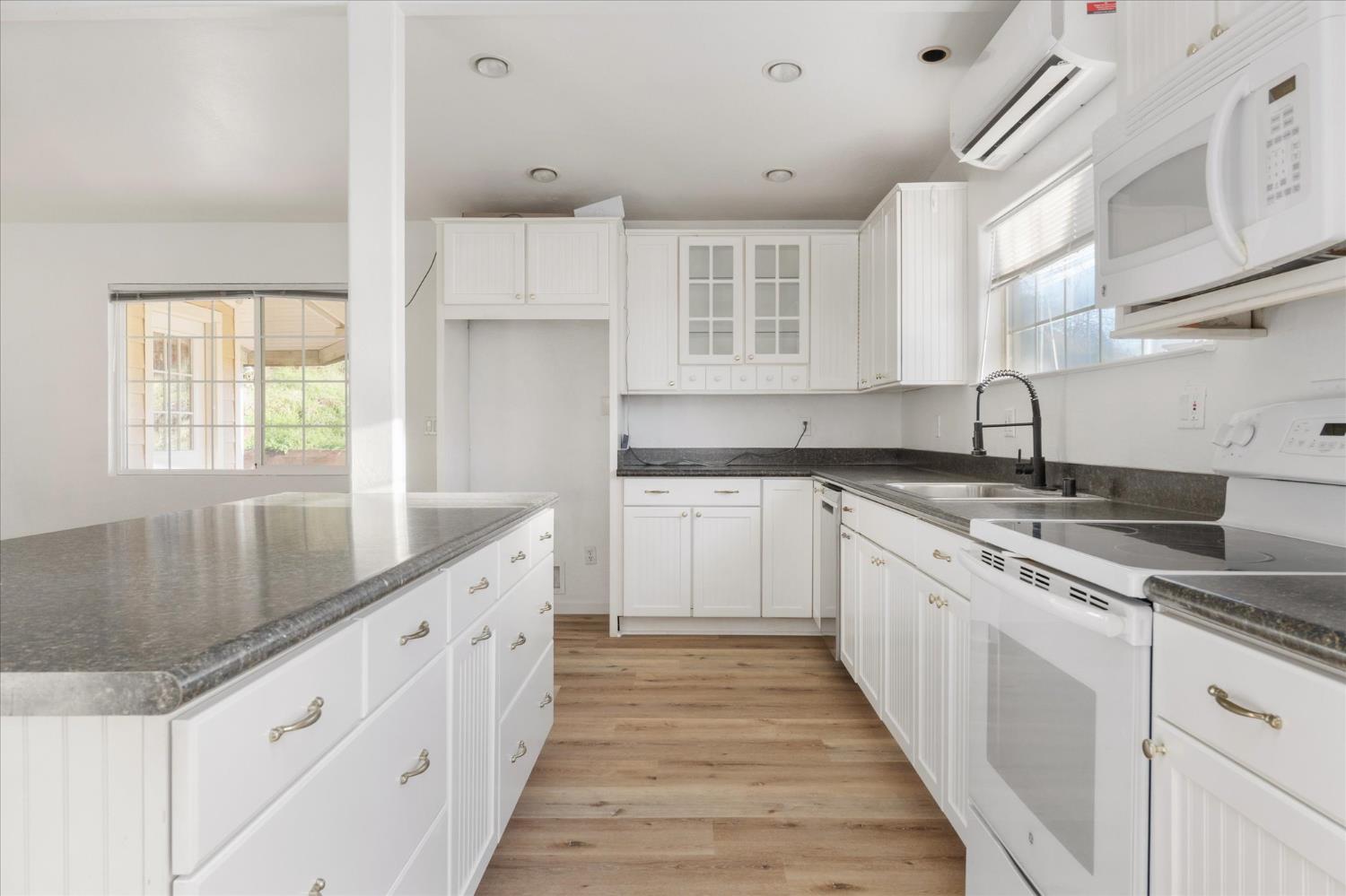 8653 Hidden Valley Road Mountain Ranch, CA 95246 - Photo 13 of 41 a kitchen with granite countertop a sink stove and cabinets