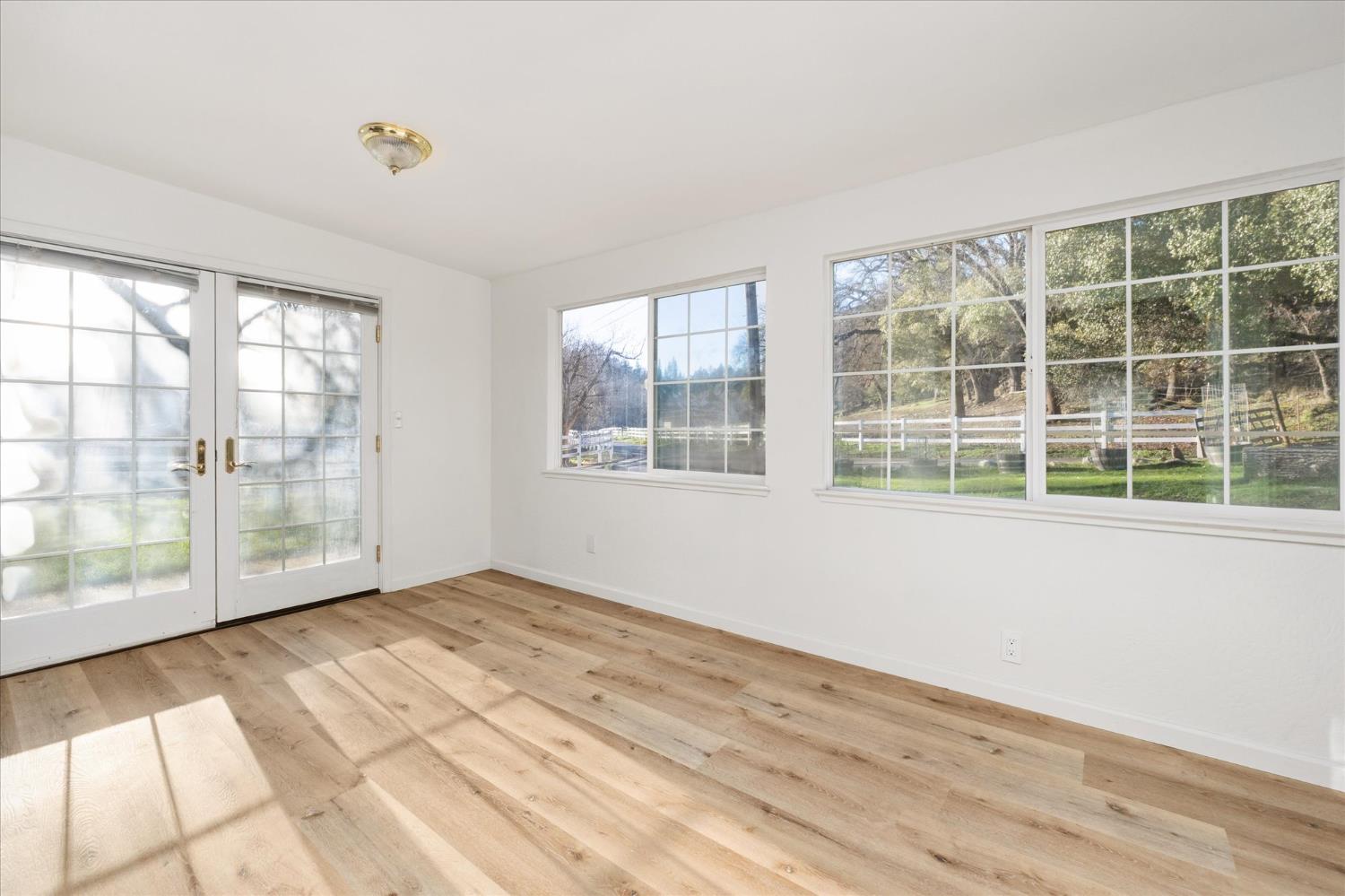 8653 Hidden Valley Road Mountain Ranch, CA 95246 - Photo 17 of 41 a view of an empty room with wooden floor and a window