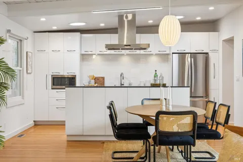 a kitchen with kitchen island a dining table and chairs
