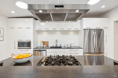a kitchen with stainless steel appliances a stove a sink and a refrigerator