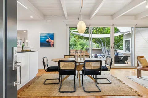 a view of a dining room with furniture a chandelier and wooden floor
