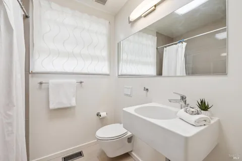a bathroom with a sink mirror and toilet